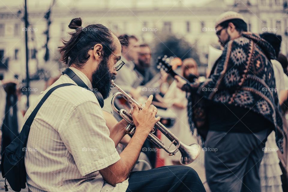 Trubach plays a street theater actor on a pipe