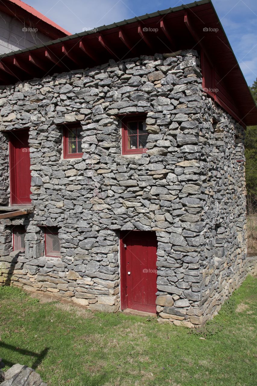 Old stone building with red doors and windows.