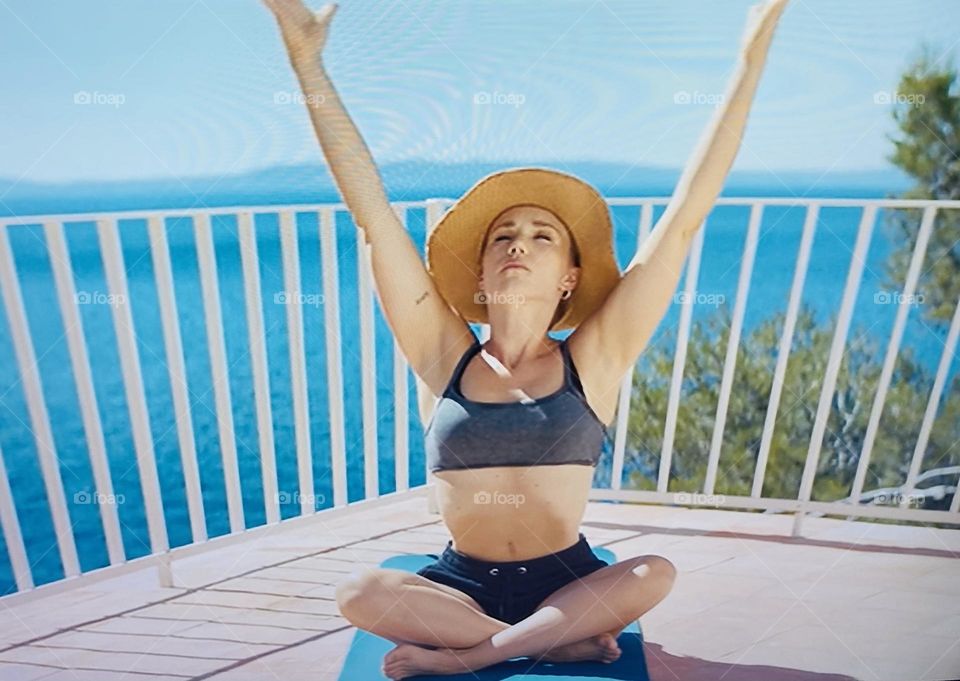 Girl on mat doing yoga at the beach 🏝