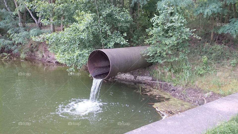 flowing water from a pipe into a lake