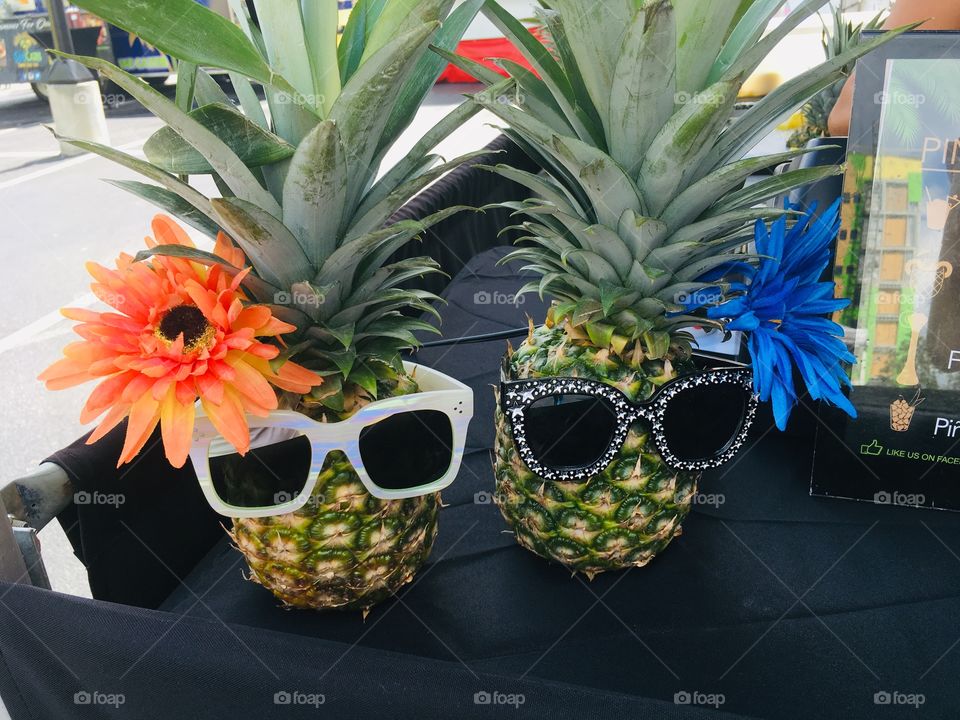 Pineapples with flowers and sunglasses 