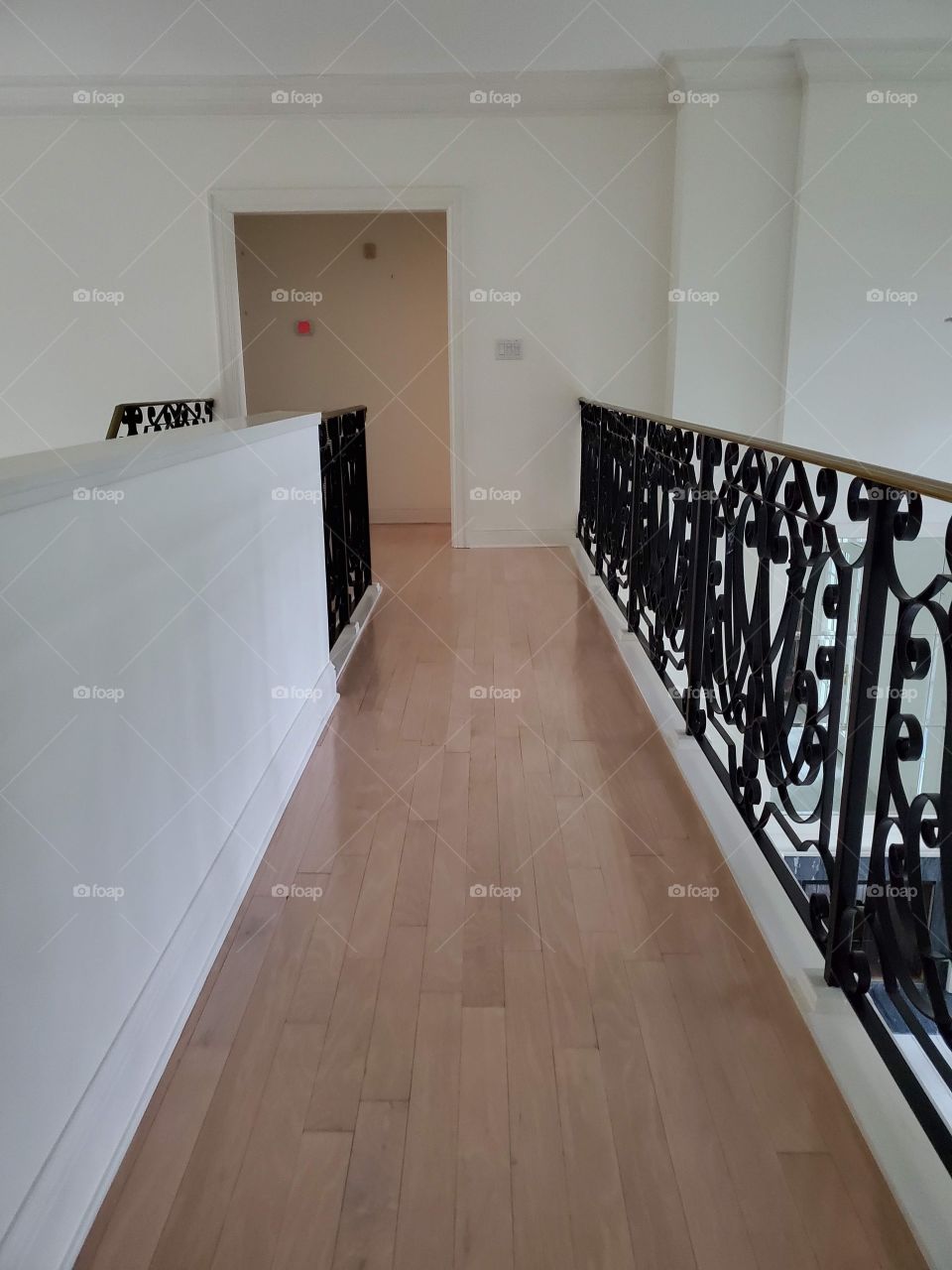 Hallway with wrought iron handrails and white wall