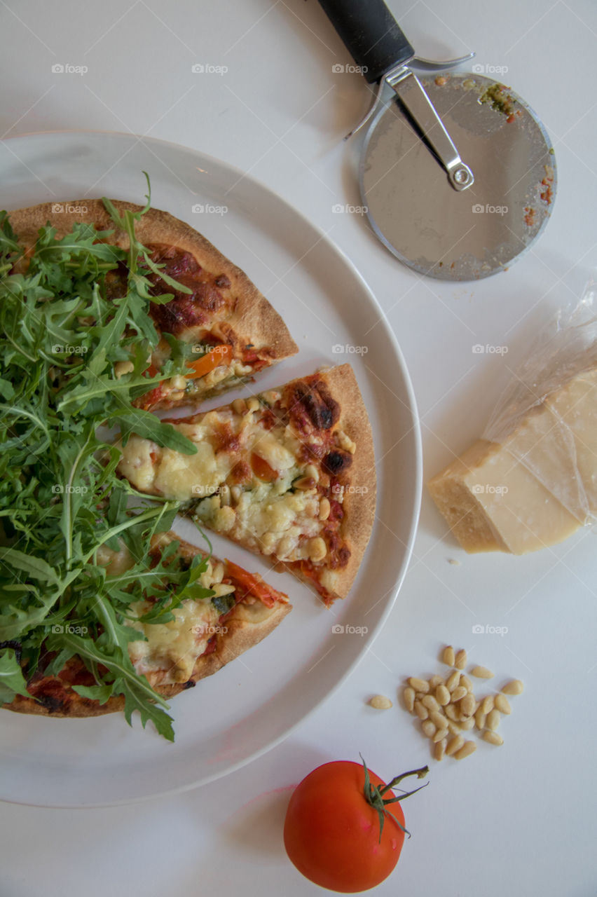 Fresh pizza out of the oven topped with arugula