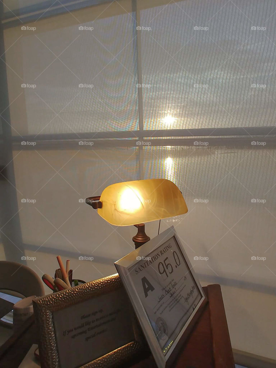 Lamp and sanitation grade at local seaside restaurant with sunset and inlet water in background.