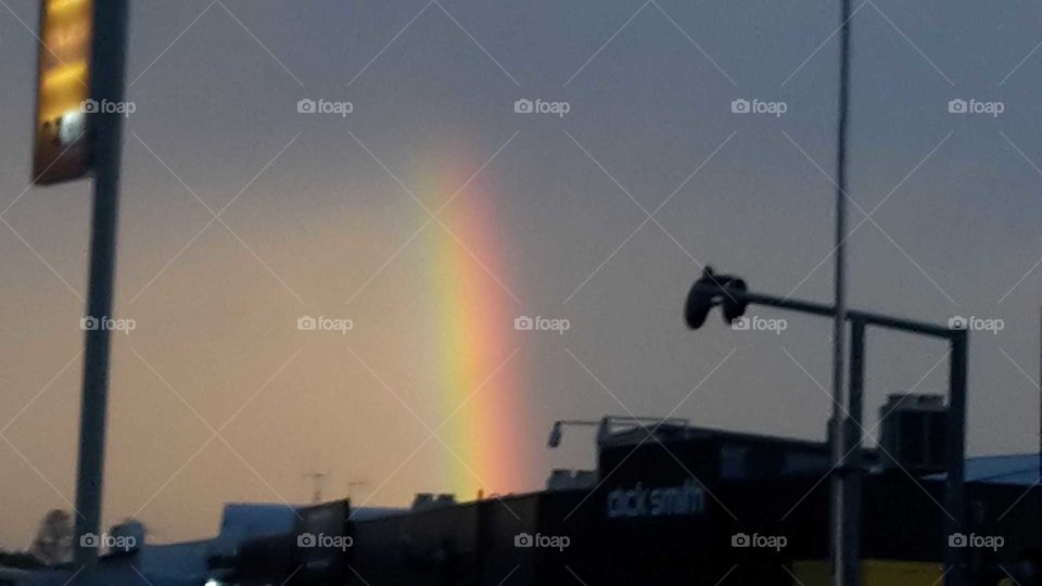 Part of an intense bright rainbow lights up the sky on an over cast day. Natures gorgeous scenes never cease to amaze me.