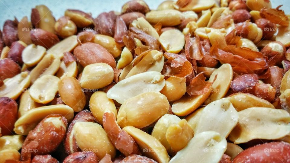 Peanut kernels, some with brown skin intact, lightly salted.