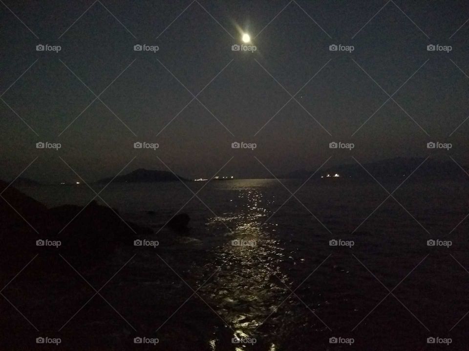 Uma linda noite de Lua cheia a beira mar.