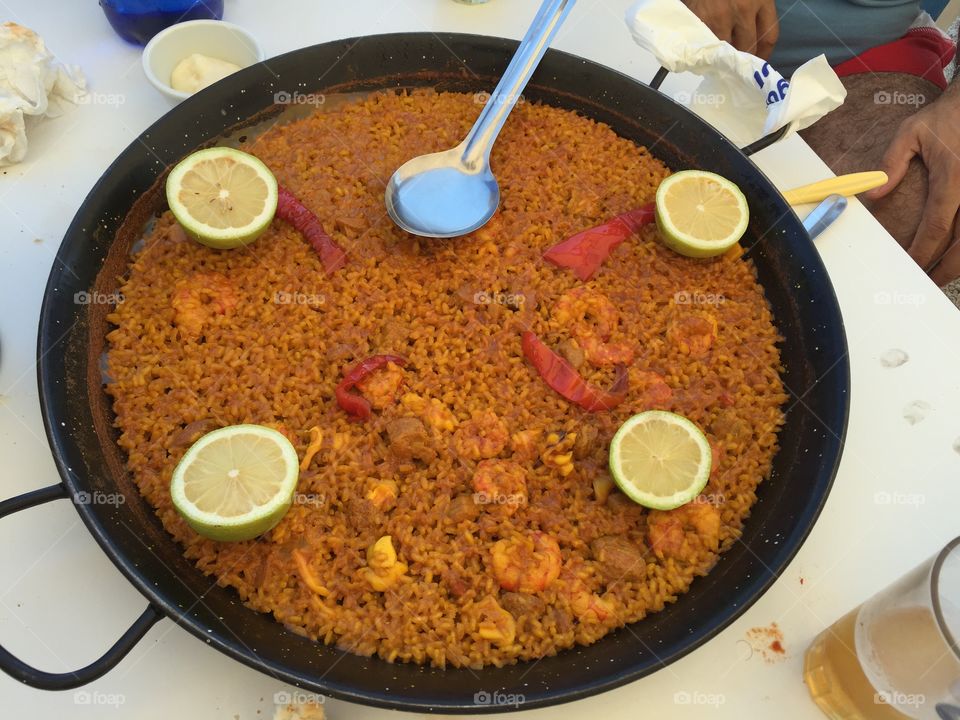 Seafood paella with shrimp and lemon slices in Spain. 
