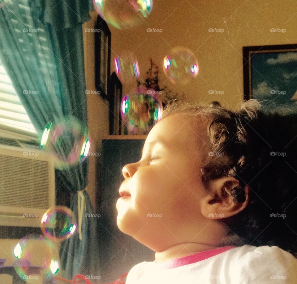 Bubbles. A toddler enjoying her bubbles thoroughly. 