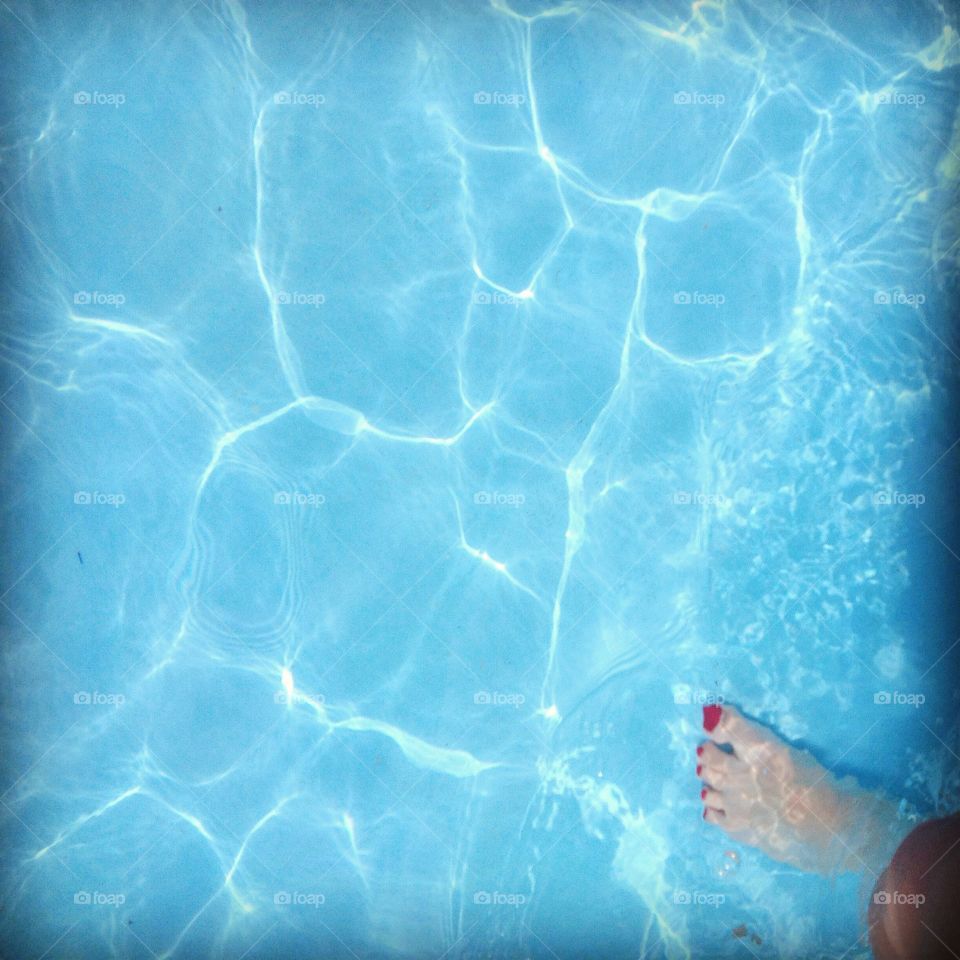 Stepping into the clear blue swimming pool on a hot summer day.