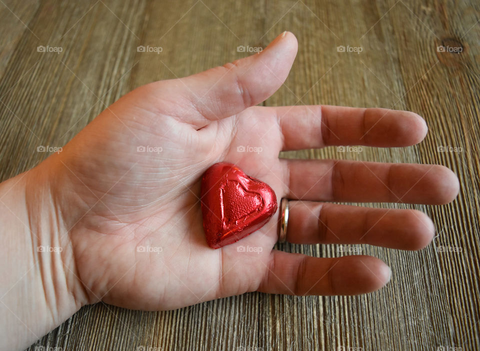 Hand holding heart shaped candy