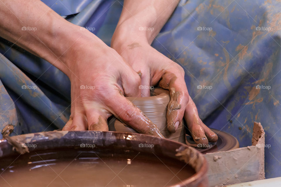 Learning pottery - man making a pot of clay