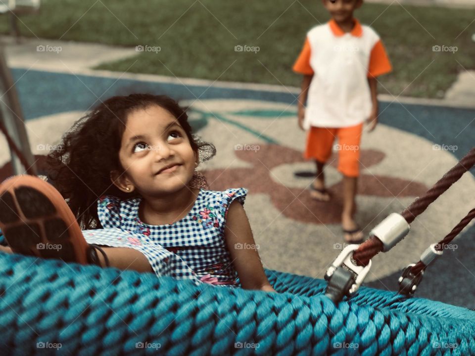 Kids playing at park and swinging and enjoying.