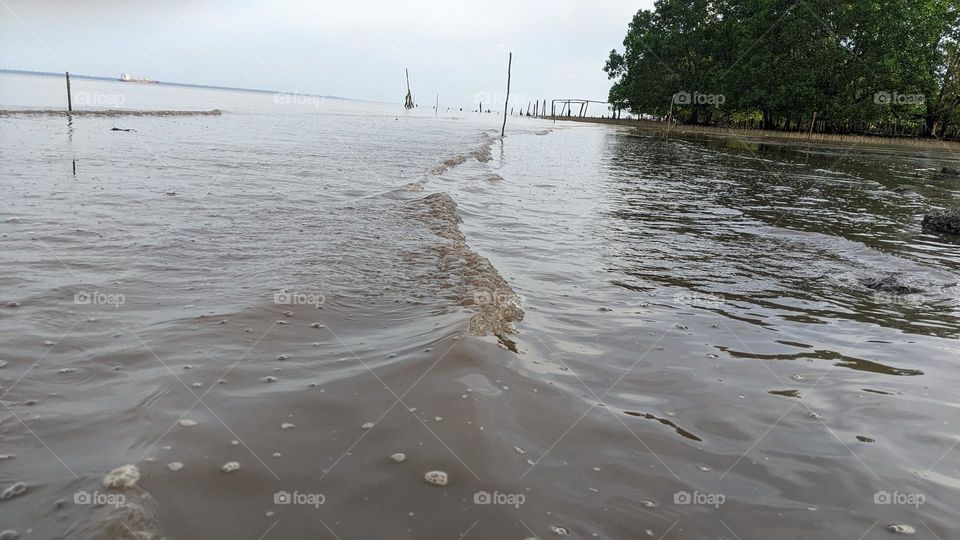 small waves crashing onto the beach at sei pakning dock