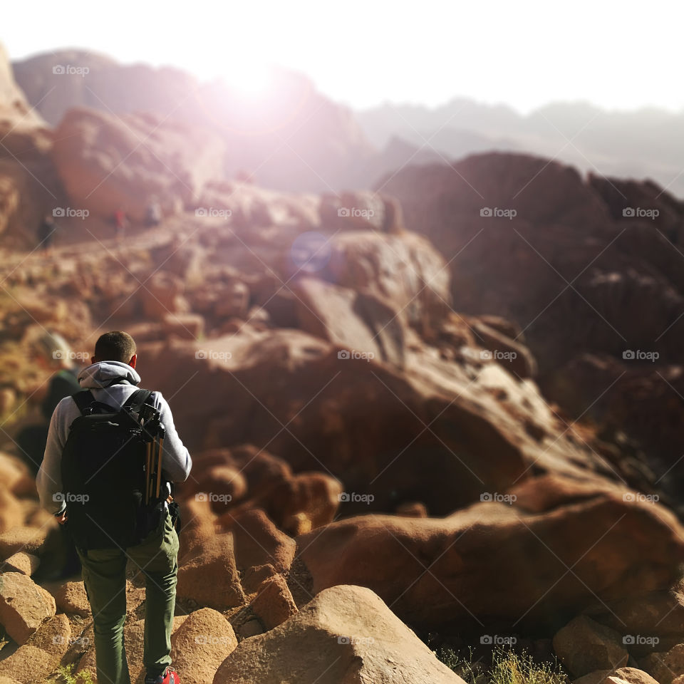 Young man with a backpack hiking through the mountains 