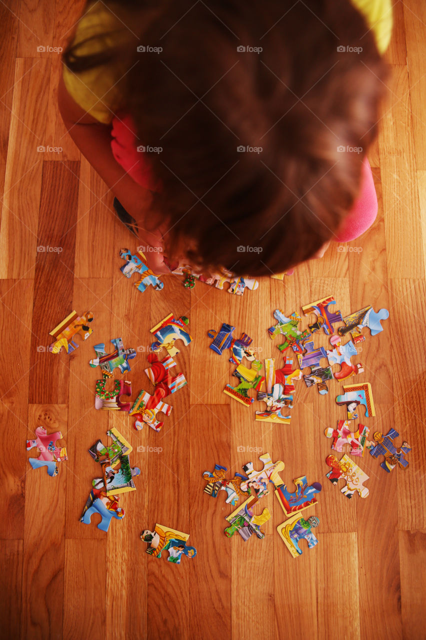 little girl putting together puzzles