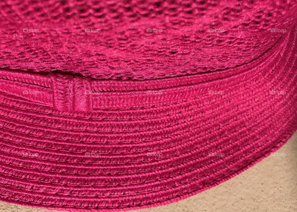 Close up of a pink woven hat.