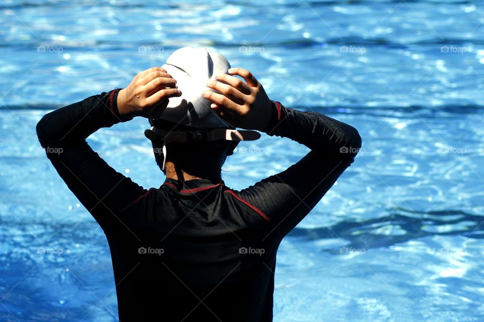 a young kid prepares to swim in a swimming pool