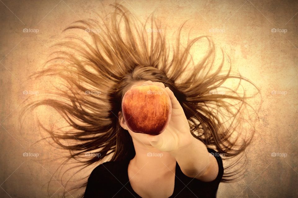 Girl holding apple with extended arm