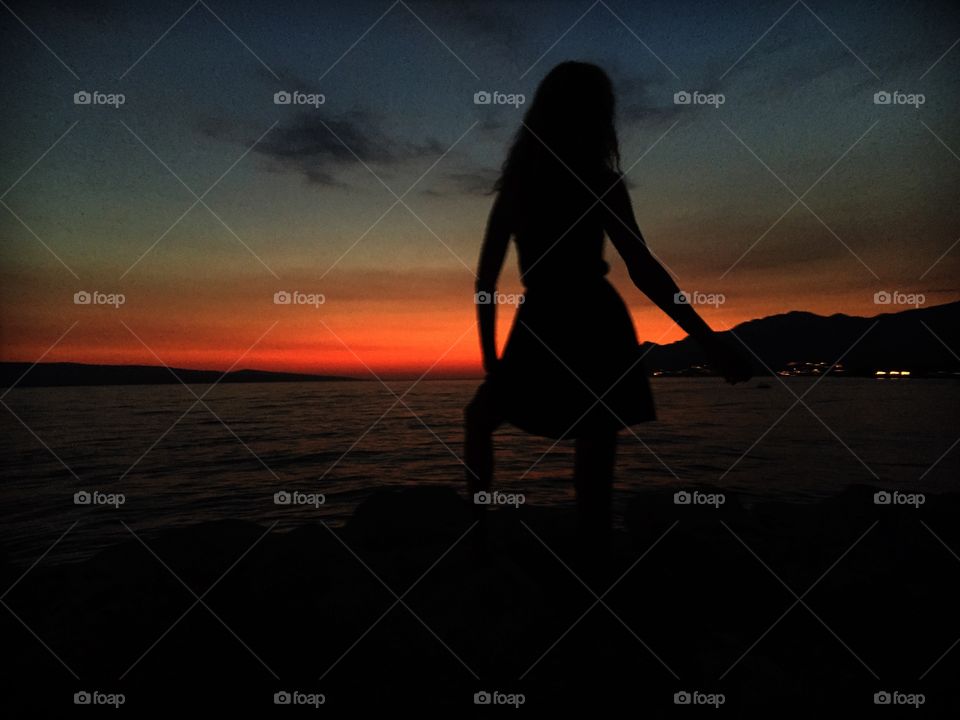 Colorful sunset- silhouette of a girl in Dubrovnik Croatia 