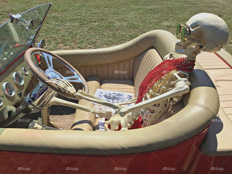 Cars with soul - A skeleton with his sunglasses on sits behind the wheel of a Ford Roadster. 