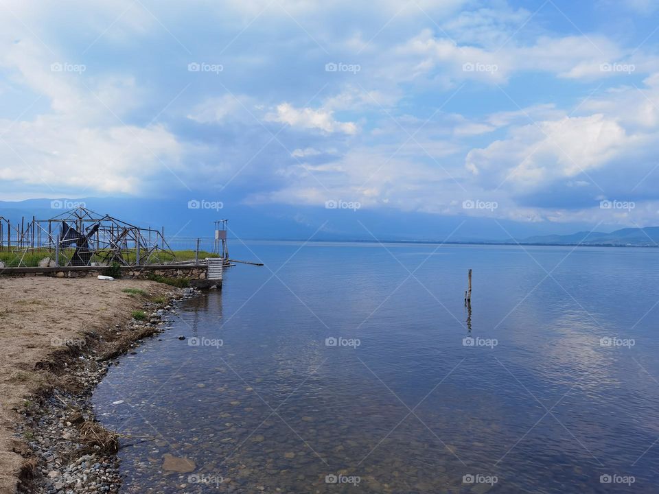 Cloudy sky upon blue water
