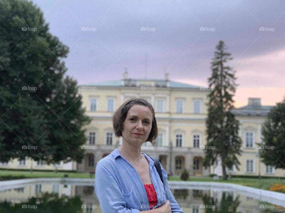 Portrait of a smiling woman, old building, park 