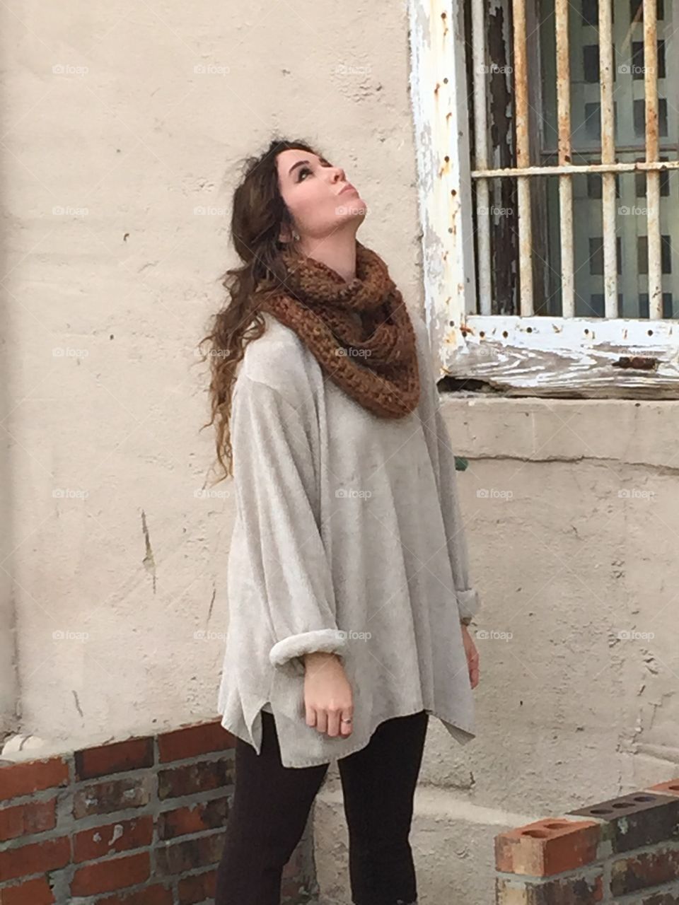 Pretty woman standing near old house