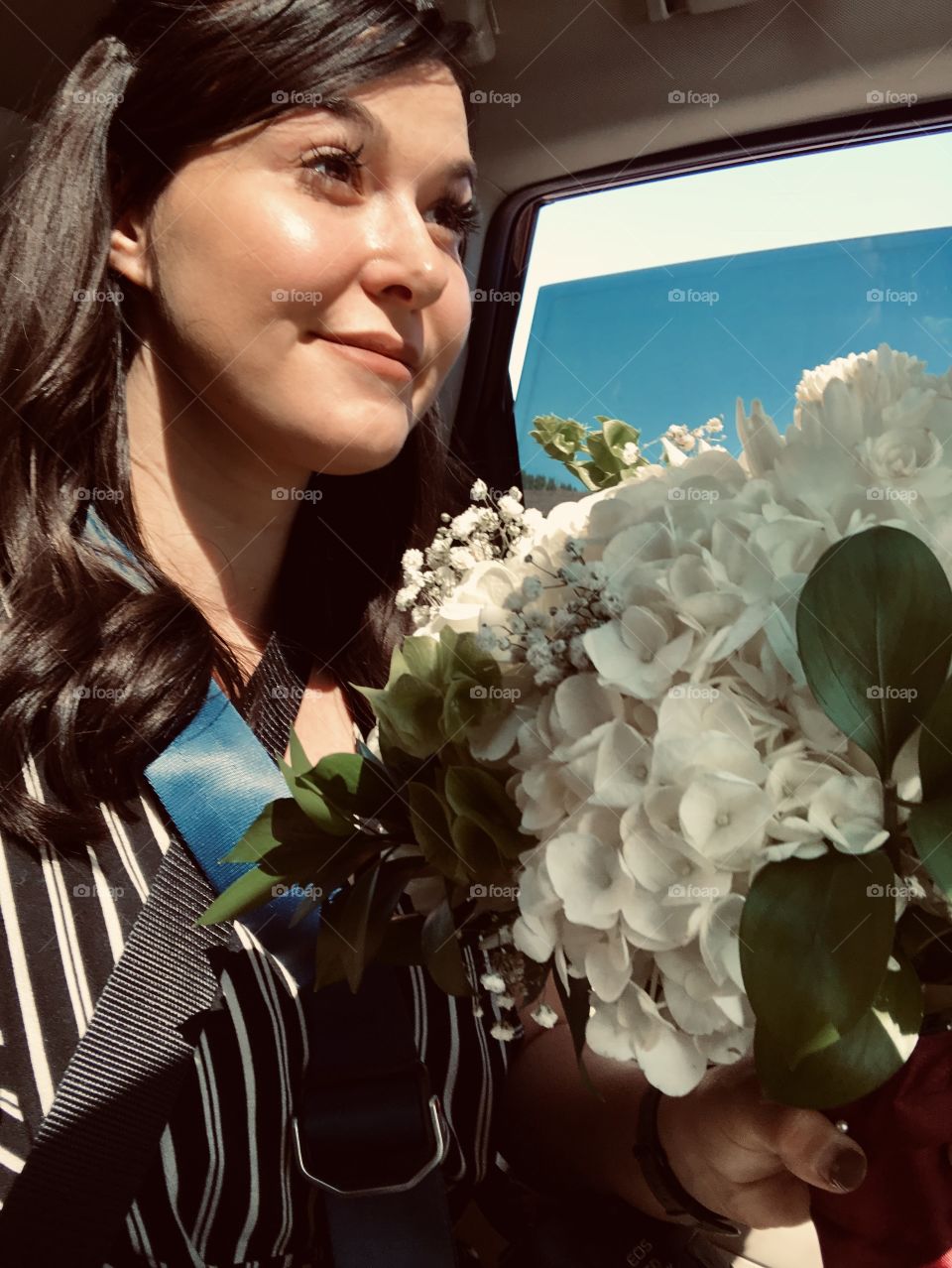 Photographer holding bouquet of flowers for the bride on the way to photograph the bride and grooms first look. 