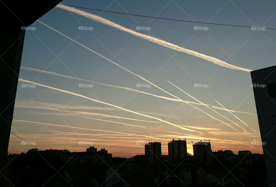 Chemtrails before sunrise in the city