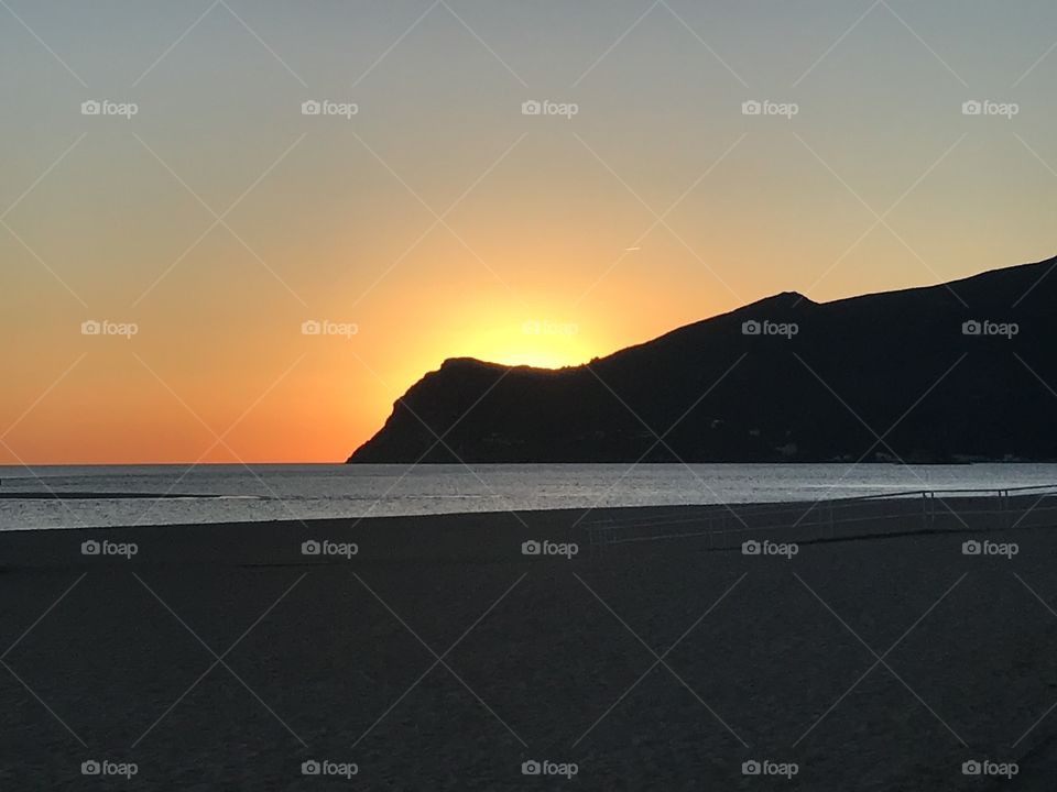 Sunset behind the mountain at the seaside