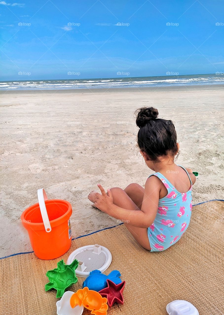 Child playing in the sand on the beach