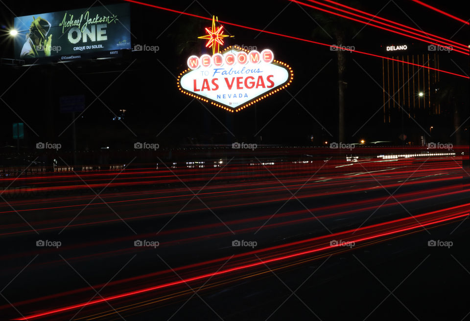 Nighttime light trails photography in front of the famous landmark, the Las Vegas welcome sign on the Las Vegas Strip.