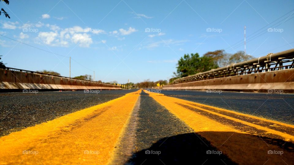 Rodovia. Pista com faixas amarelas.