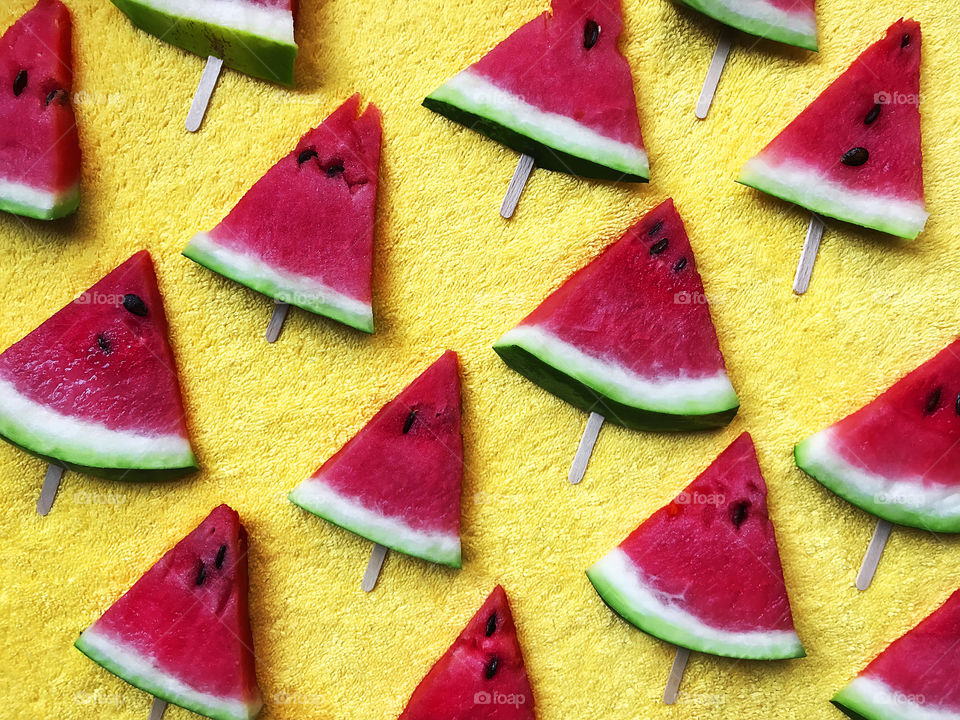 Triangles of red watermelon on yellow background 