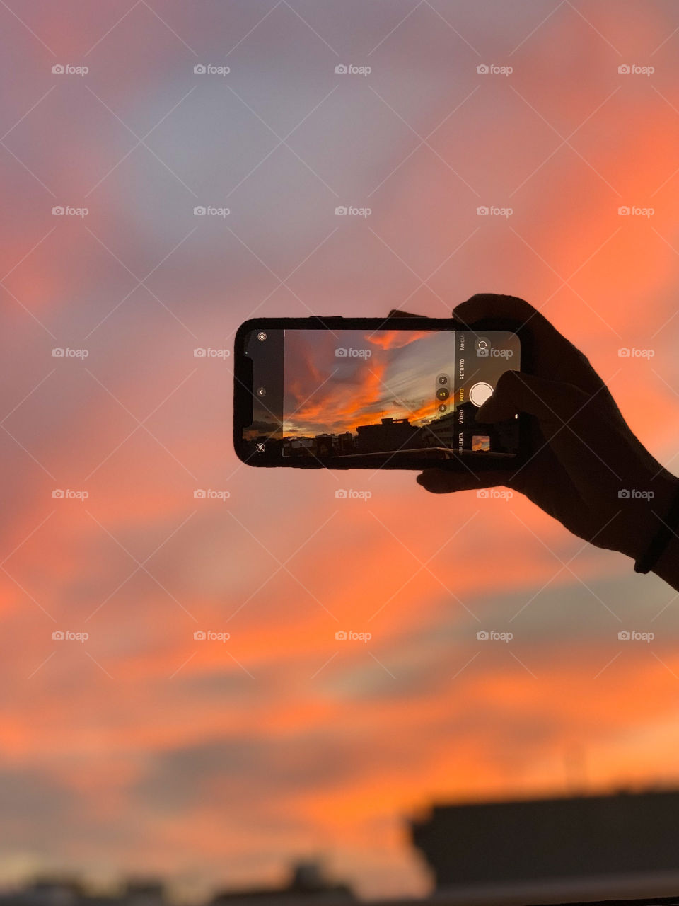 Photo of a mobile photographing the city while sunset