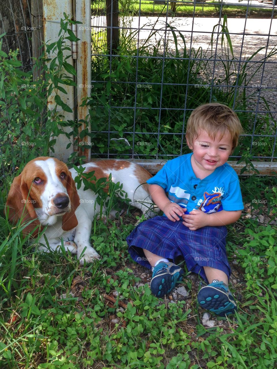 Our grandson and our dog Roxie setting in the corner of the yard. Like they waiting to get into something.