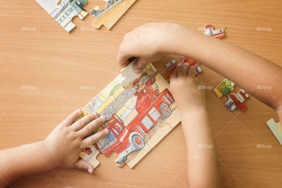 Children playing puzzle on table