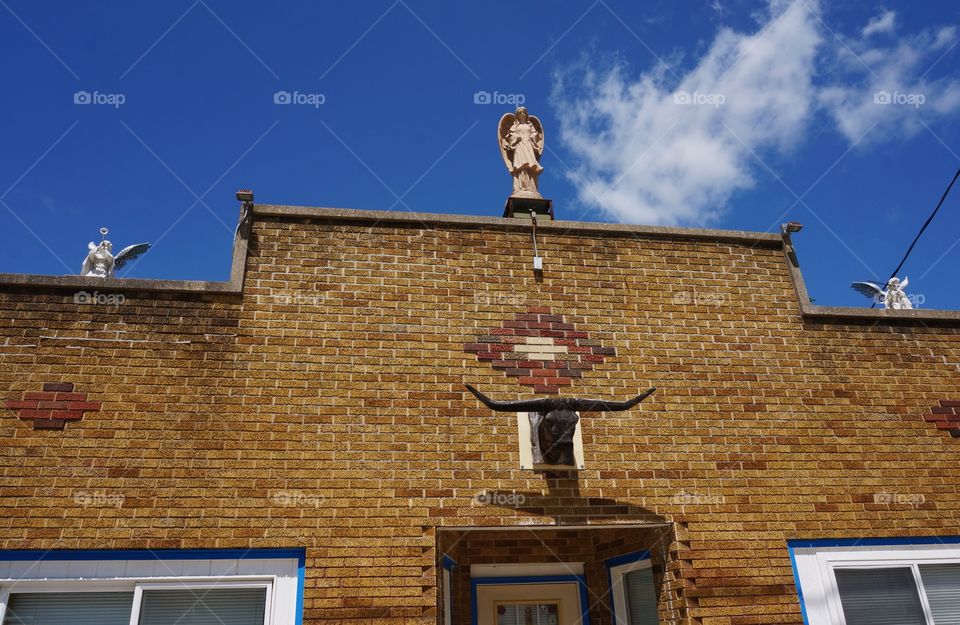 Statues on Roof of Building. Angels with Wings