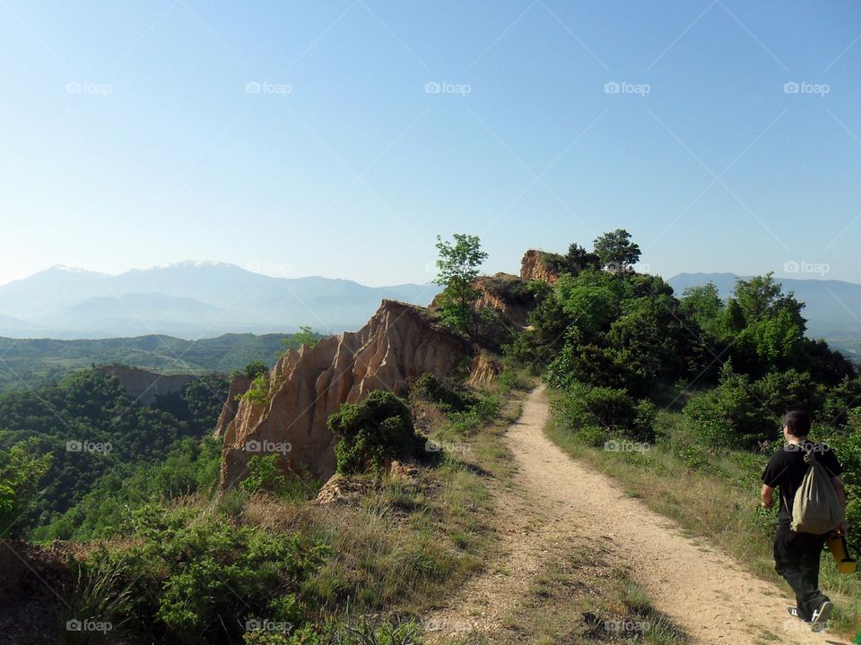 A person walking on trail over the mountain