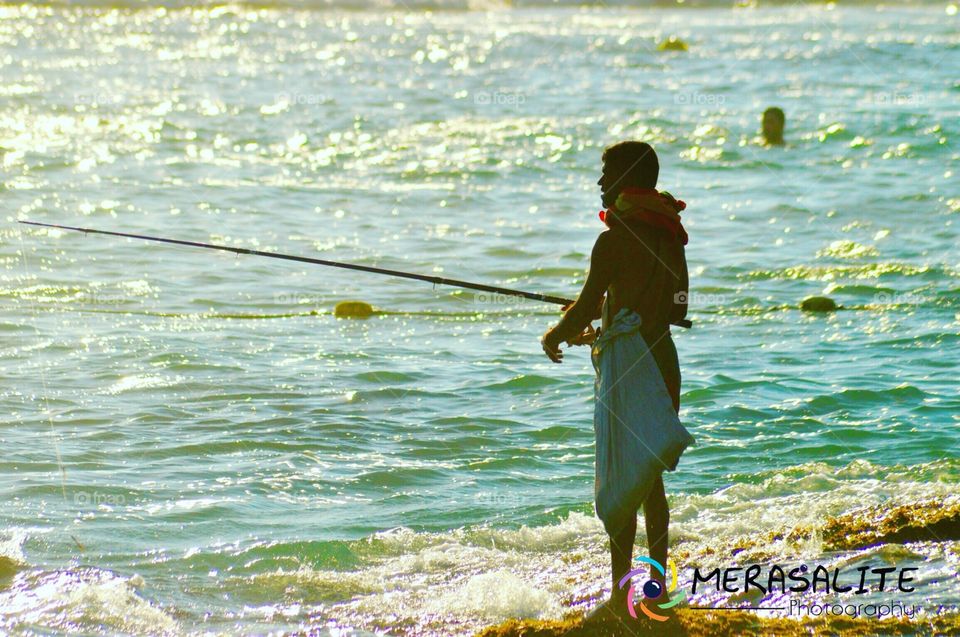 Fisher man ...  One of happy's job in world ... 
One boring day .. Really I don't know what's to do . 
And I take my cam and ride my bike alone on way to matara road .. I am stop and beach side wake alone with my cam . And I see the fisher man .. He is really happy and enjoy he work. I take my cam and click This pic .. 
