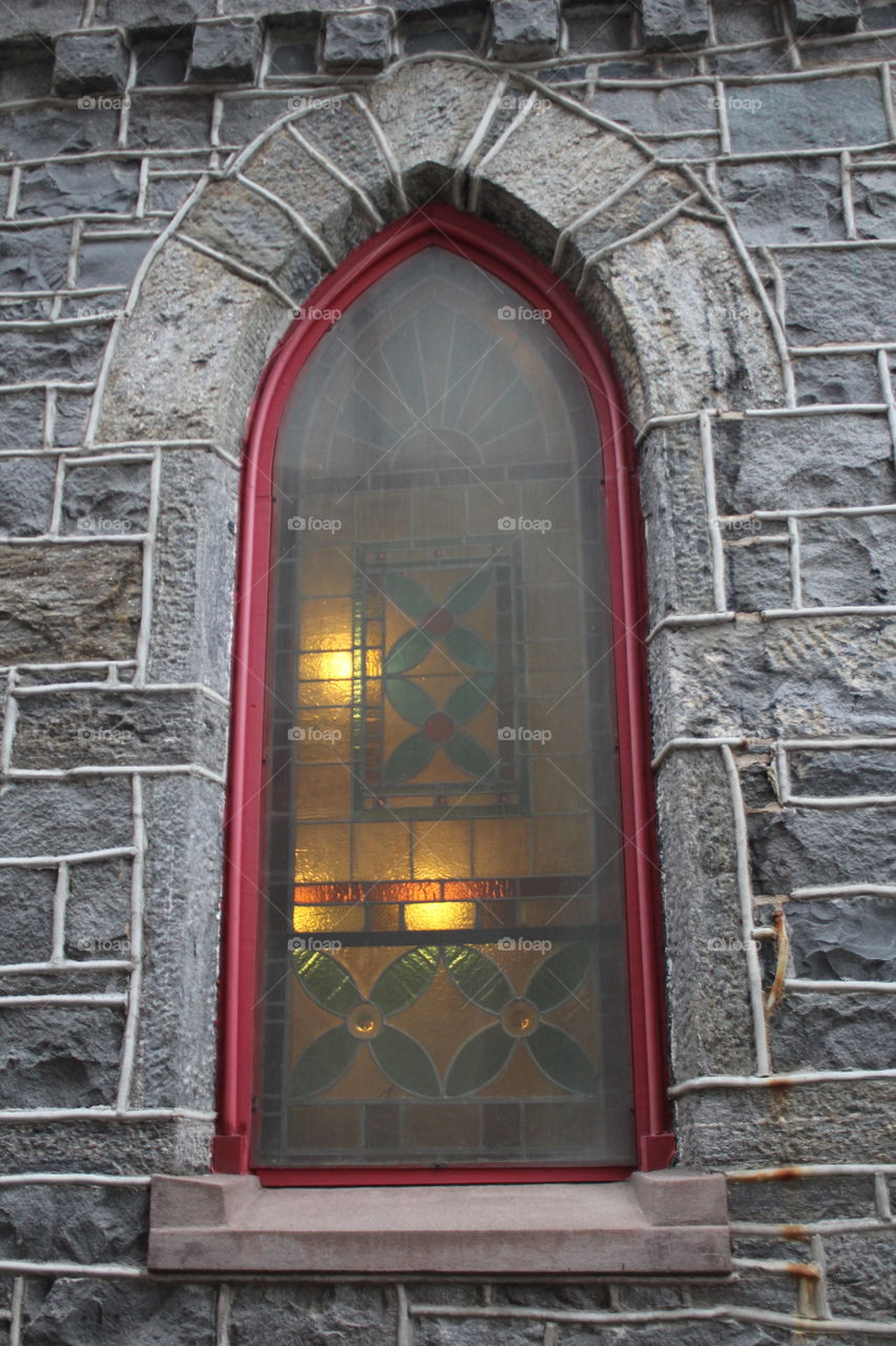 Lighted window of All Saints Episcopal Parish (Trinity Church, founded 1853) in Hoboken, New Jersey 