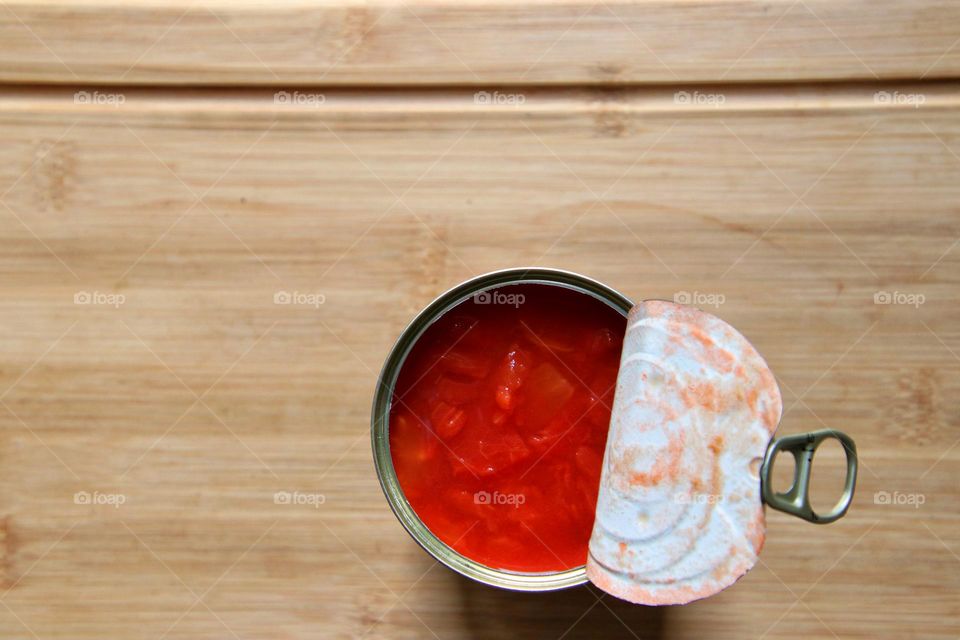 Close up view from above of an opened can of tomatoes