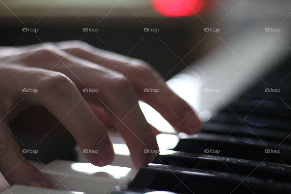 The musician’s fingers, skillfully playing the keys of a piano. 