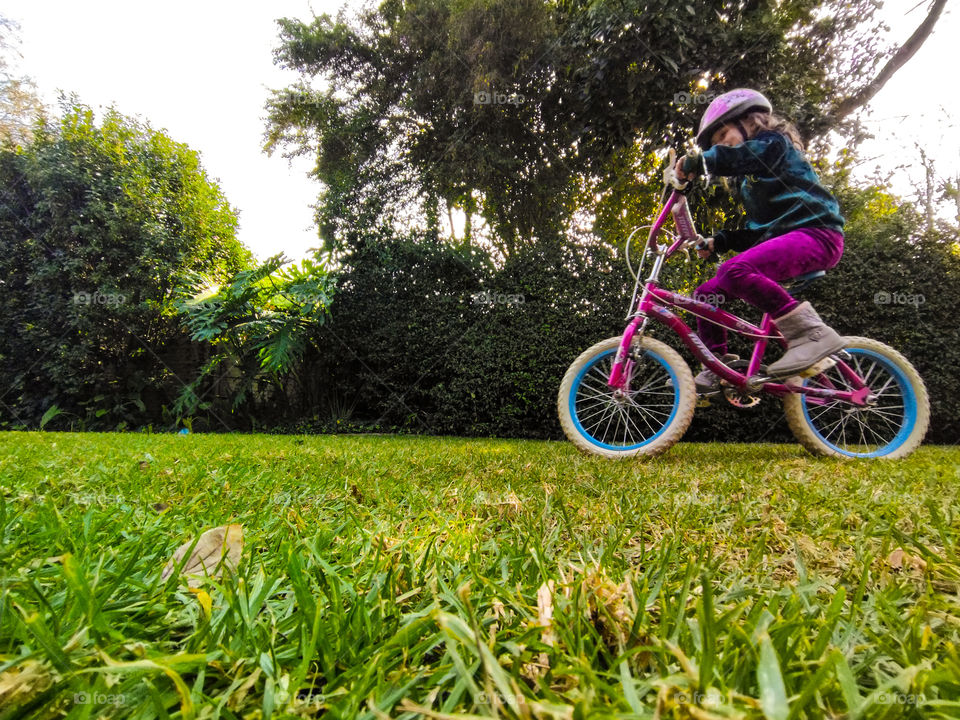 Girl with helmet riding her bike