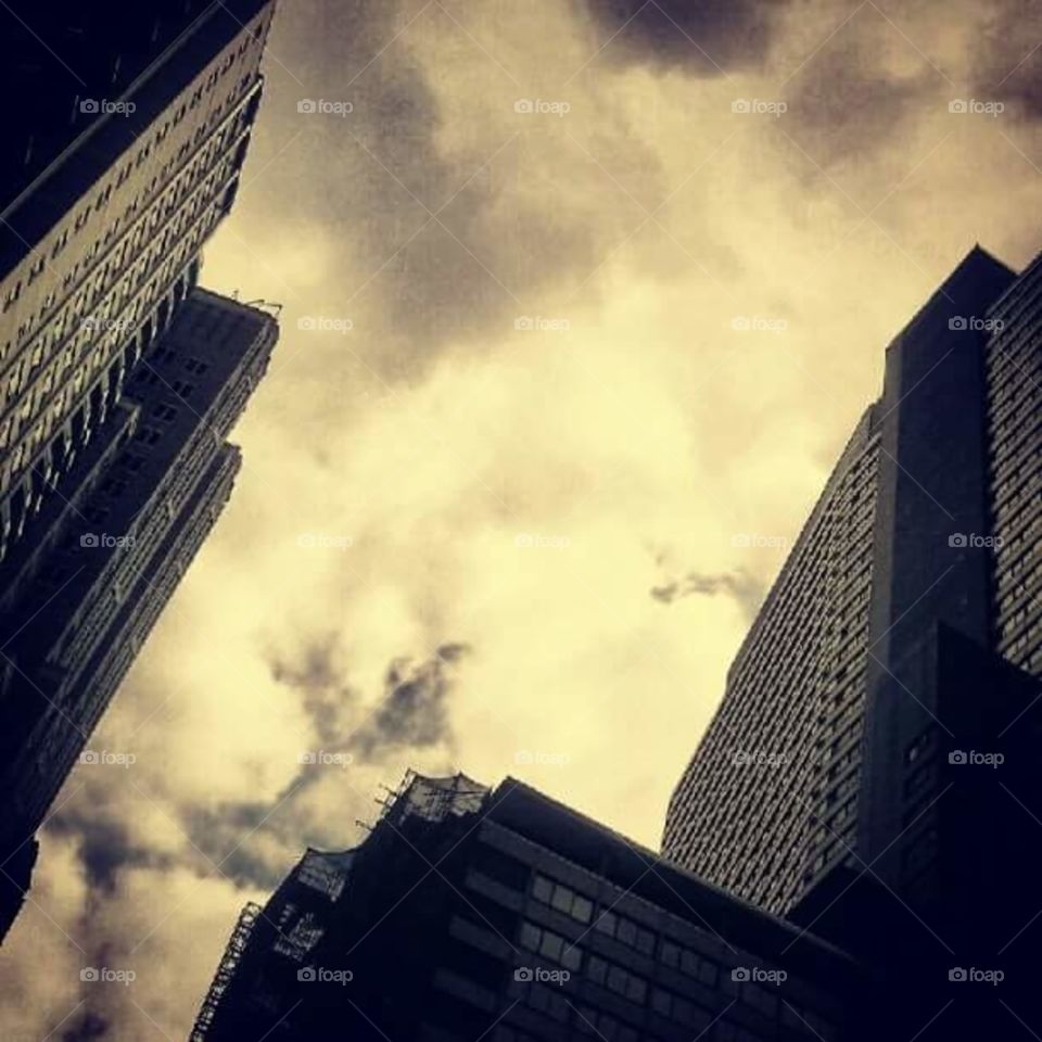 Manhattan, NYC, shot of the fantastic giants on 53rd and 7th rising above the people. They reach the clouds above.