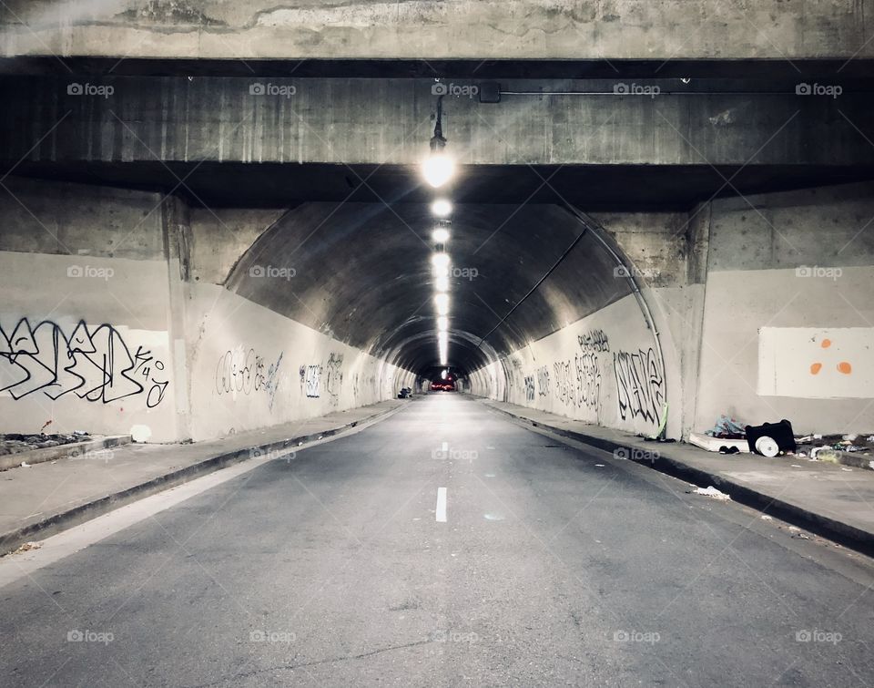 Graffiti and piles of trash at the entrance to an old tunnel going through Downtown Los Angeles CA 6.10.2020