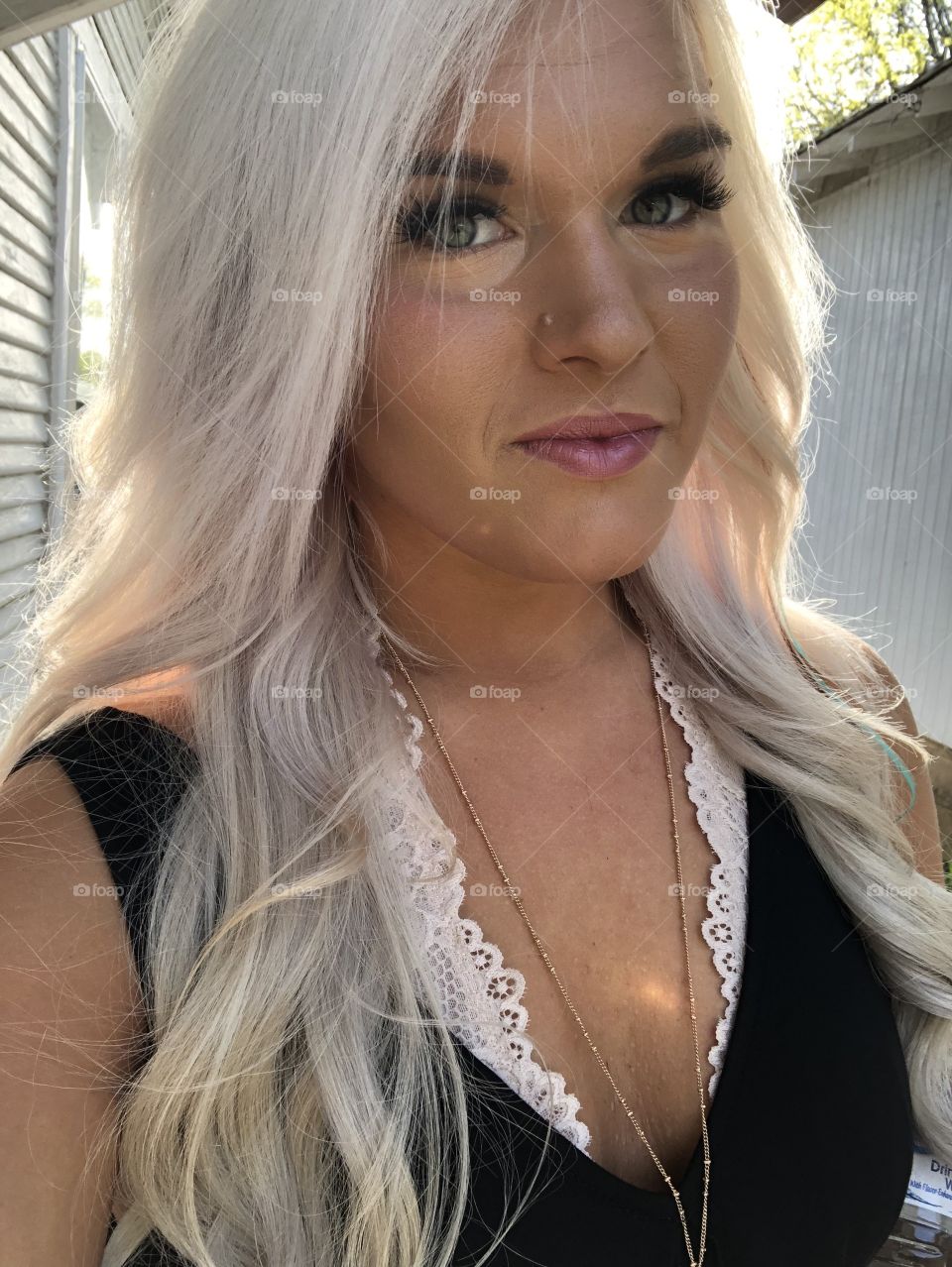 Makeup selfie. Blonde girl uses LimeLife professional makeup brand. Natural lighting 