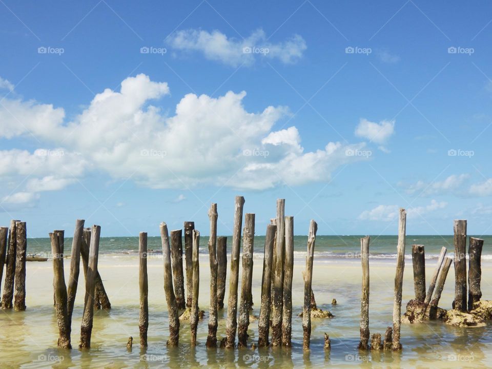 paisaje de playa paradisíaca con pilares de madera de un antiguo puente o embarcadero