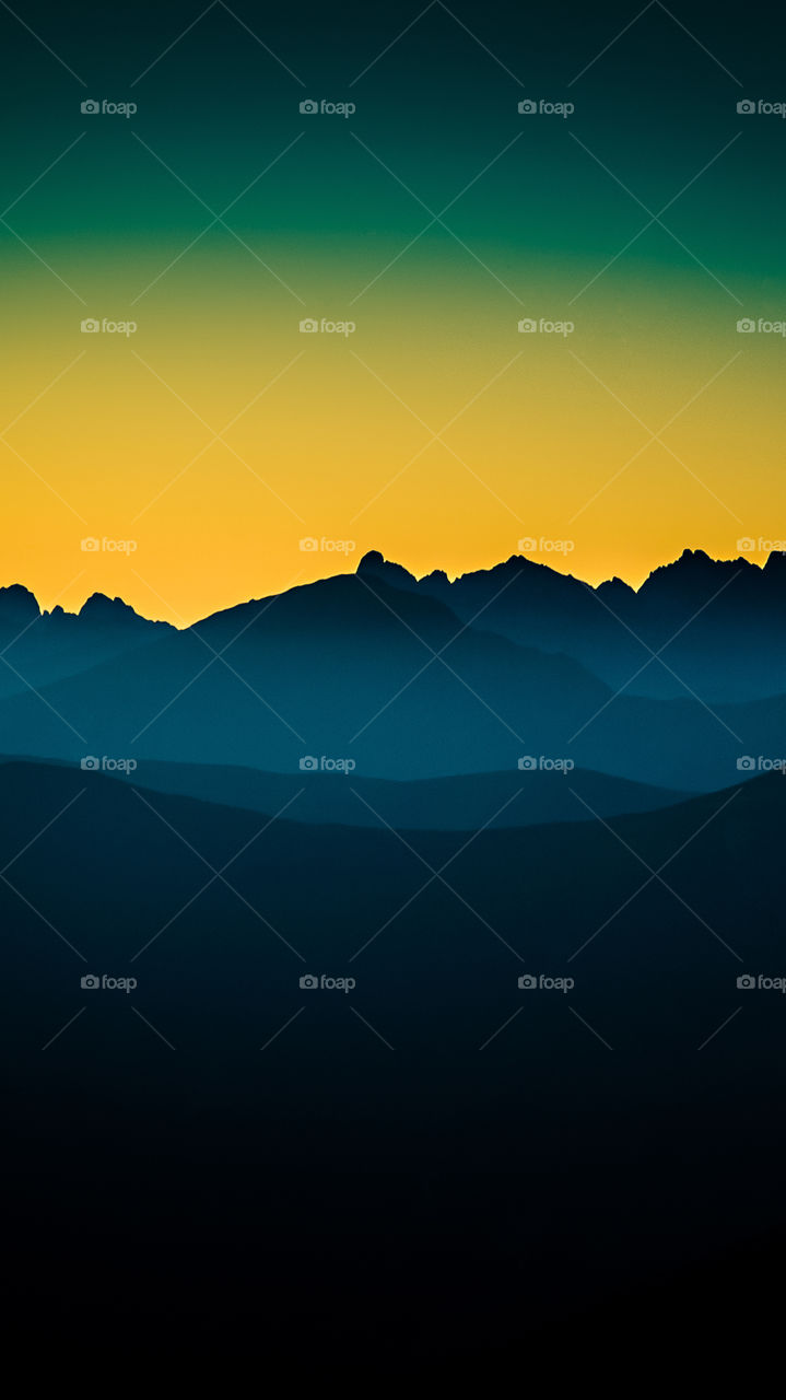 An inspiring mountain landscape. Tatry mountains in Slovakia. A beautiful wallpaper for smartphone screen. Warm summer haze, abstract gradient with perspective.